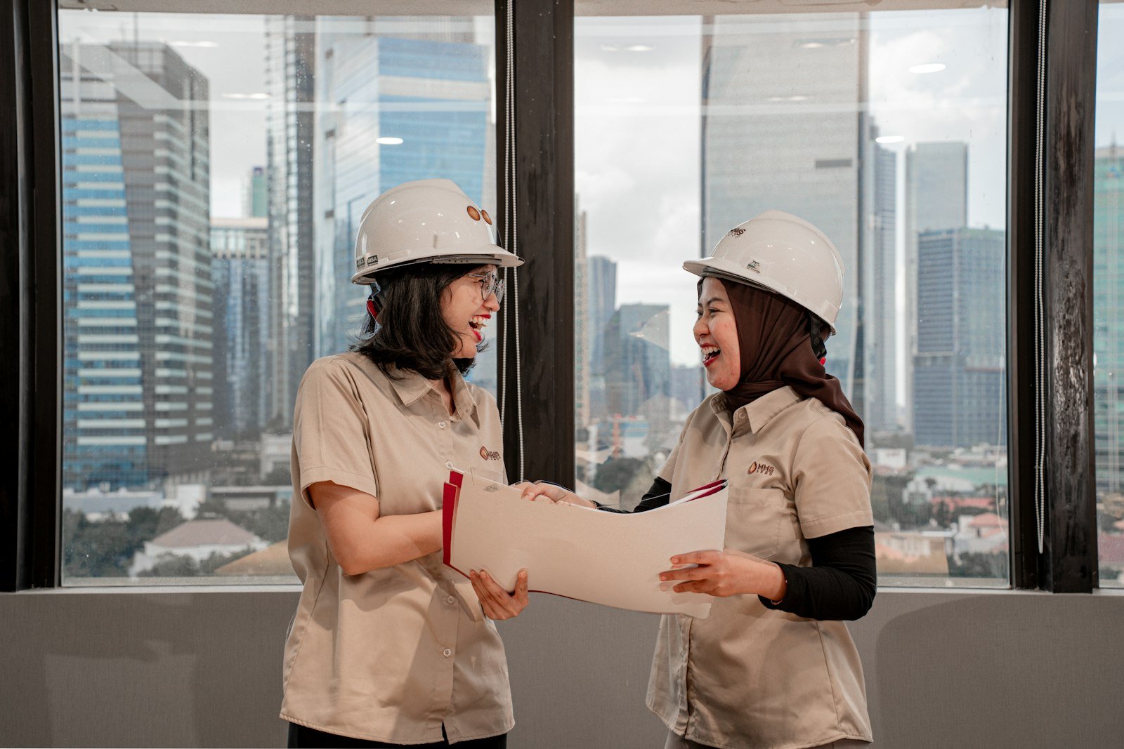 Engineers in hard hats discussing plans on site